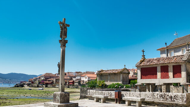 Cruz de piedra y tradicionales h&oacute;rreos gallegos en la hermosa villa medieval de Combarro, Espa&ntilde;a