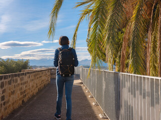 Young woman strolling through charming narrow streets of Denia, Alicante province, Spain, surrounded by historic Mediterranean architecture , enjoying peaceful atmosphere and cultural ambiance.