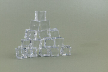 Ice cubes arranged in a pyramid shape on a plain background