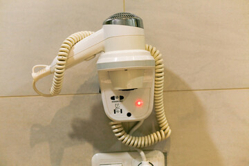 close up of hair dryer hanging on the wall bathroom hotel