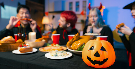 Dinner and group of people celebrating together at Halloween party.