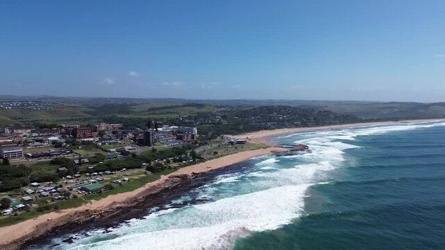 Camera panning along the beautiful coastline of the South Coast of KwaZulu-Natal over the coastal town of Scottburgh, Aerial 4K video.