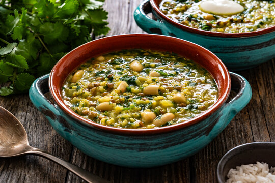 Aash-e Jow - persian barley soup on wooden table