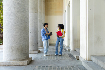Diverse students talking on university campus path