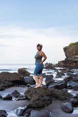 Fototapeta premium Relaxed Portrait of Smiling Woman Sitting on Beach Rocks Landscape