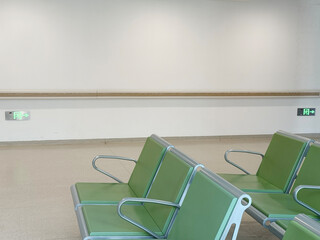 Empty waiting area with green chairs in a clean hospital setting