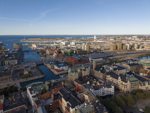 Aerial view of the vibrant canals snaking through the city's heart, contrasting with modern architecture, Malm&Atilde;&para;hus Castle, and Turning Torso piercing the horizon, Malmo, Skane County, Sweden.