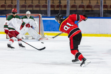 Ice hockey player shoots the puck against the opponents net