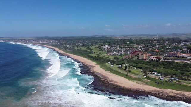 Camera panning left to right over the beautiful coastline of the South Coast of KwaZulu-Natal, over the coastal town of Scottburgh, Aerial 4K video
