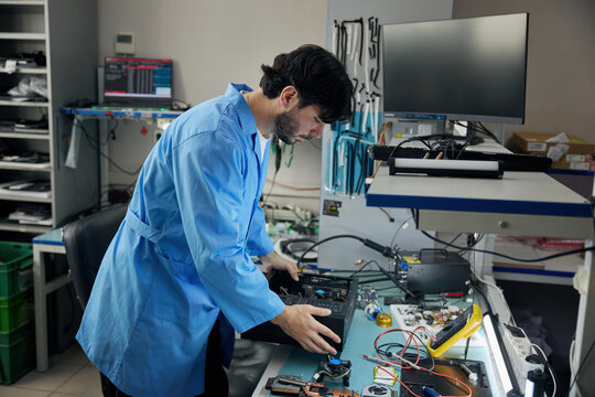 Portrait of a man soldering technician, wearing a pair of protective goggles in a lab