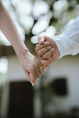 A close-up of a couple holding hands, symbolizing love, care, trust, and a romantic relationship with warmth and connection.