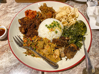 White rice surrounded by pork cooked in various Indonesian cooking methods.White rice At The Center, Surrounded By rica pork, sei pork. 