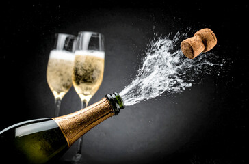 Bottiglia di champagne stappata, 2 bicchieri sullo sfondo nero