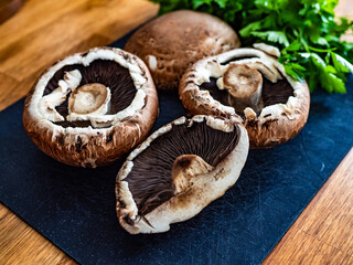 Raw portobello mushrooms on wooden table