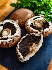 Fototapeta premium Raw portobello mushrooms on wooden table