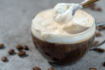 ウィンナーコーヒー（アインシュペナー）のクリームをスプーンですくう