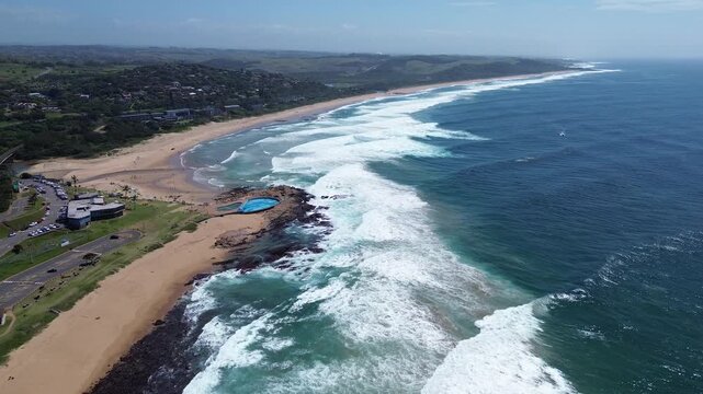 Camera pushing in along the beautiful coastline of the South Coast of KwaZulu-Natal over the coastal town of Scottburgh, Aerial 4K video.