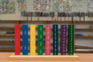 Practical wooden material Fraction Tower according to the Montessori method for alternative learning of mathematics, namely the concept of fractions in preschool and primary schools.