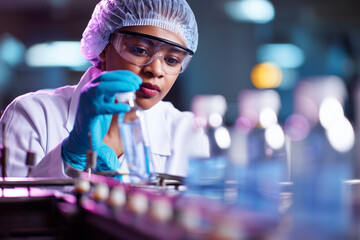 Focused Mixed Race Female Pharmaceutical Technician Analyzing Vials in Medicine Production Lab