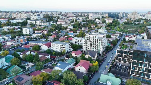 Aerial shot over Iasi city center, revealing the iconic Metropolitan Cathedral and the continuous line of people gathering for the Saint Parascheva event