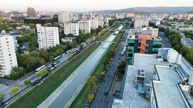 Aerial drone shot over Iasi, Romania, showing the Bahlui River and long lines of pilgrims heading toward the Metropolitan Cathedral during the Saint Parascheva celebration