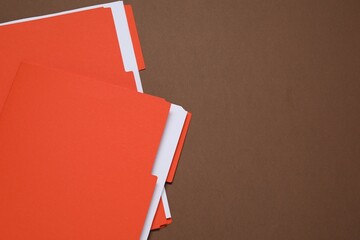 Many documents in folders on brown background, top view. Space for text