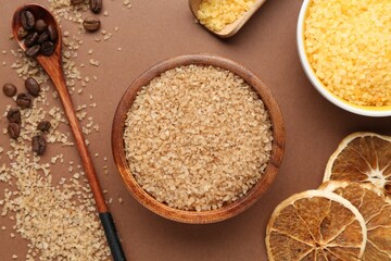 Sea salt, coffee beans and dried orange slices on brown background, flat lay