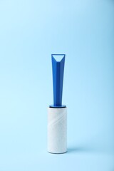 One lint roller on light blue background