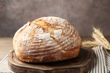 Loaf of fresh bread and spikes on table, closeup