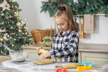 Girl baking Christmas cookies in cozy decorated kitchen