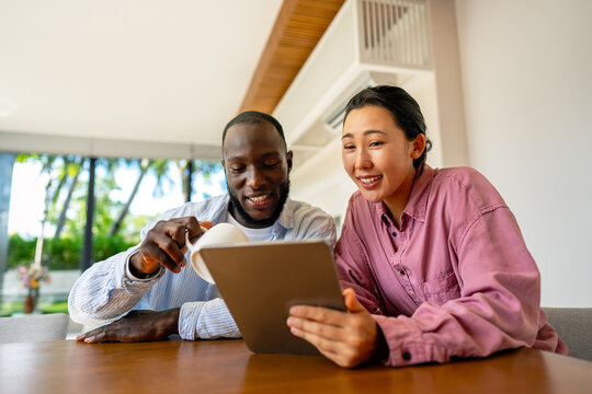 Online entertainment and social media. Diverse, multiethnic couple enjoying the digital world - Powered by Adobe