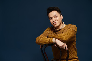 Handsome young Asian man smiling confidently while posing in a cozy studio setting