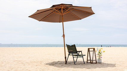 Beach chair and umbrella on sand with sea view and summer vacation relaxation concept