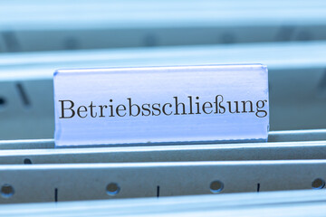 Schild mit der Aufschrift BETRIEBSSCHLIESSUNG an einem Hängemappenregister