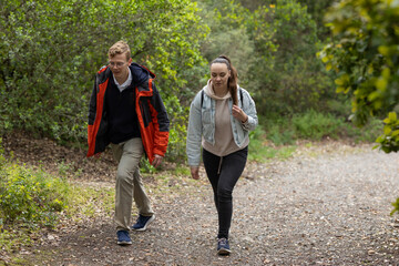 Obraz premium Young couple hiking path exploring green forest