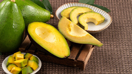 Fresh avocado with sliced and diced pieces over woven bamboo background