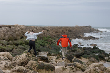 Young people exploring rocky coast enjoying outdoor adventure