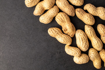 Unshelled raw peanuts, macro, top view.