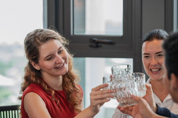 Happy Business Team Celebrates Success with a Toast in a Modern Office Lounge, Located in a High-Rise Office with a City View. Group of Friends Enjoying raising glasses and celebrating together.