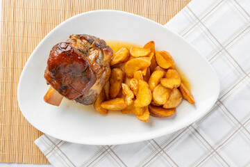 Roasted pork knuckle with potato wedges meal