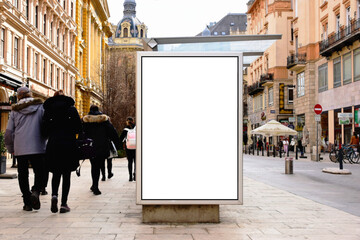 bus shelter at busstop. white poster ad display space and lightbox. mockup template. blank ad panel. glass design. urban street setting with storefronts. soft background with people's silhouettes