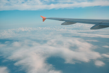 Fototapeta premium Wings touching the clouds on a sunny day during a tranquil flight over the open sky