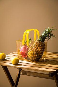 Fresh Tropical Fruits and Lemons on a Wooden Table, Pineapple, lemon and mint in a glass on a wooden table