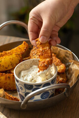 Crispy Seasoned Potato Wedges with Creamy Herb Dip, Fried potato wedges with tartar sauce. Selective focus