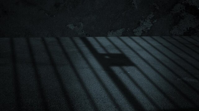 The prison cell's grate closes and casts a shadow on the prison floor. 4K