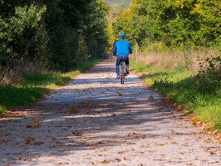 Clecy, Normandy, October 4, 2025. Autumn bike ride on a forest path. A man rides his bike on a quiet country path surrounded by trees in autumn colors