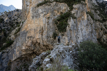 Fototapeta premium Adventurer on rocky terrain near steep cliff