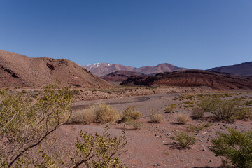 Andes desert valley with layered red and pink mountains