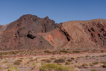 Andes desert valley with layered red and pink mountains