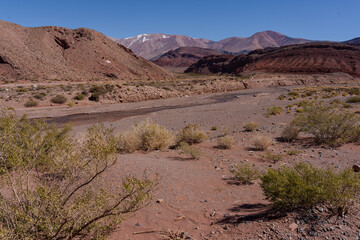 Andes desert valley with layered red and pink mountains